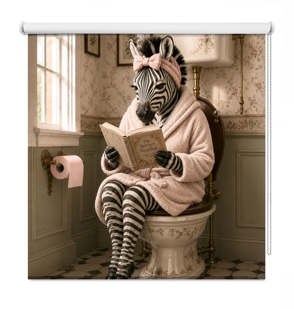 A decorative roller blind or curtain panel hanging on a white rod, featuring a whimsical printed scene of a zebra dressed in a pink robe and headband, sitting on a toilet and reading a book in a vintage-style bathroom.