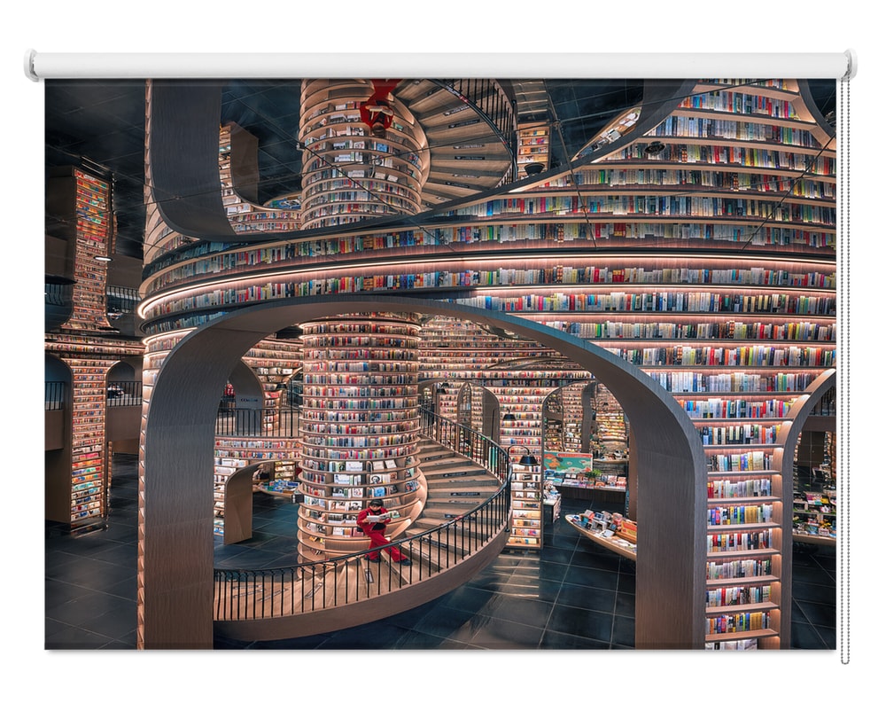 Printed roller blind featuring a dramatic futuristic library interior with multi-level curved bookshelves and a central spiral staircase
