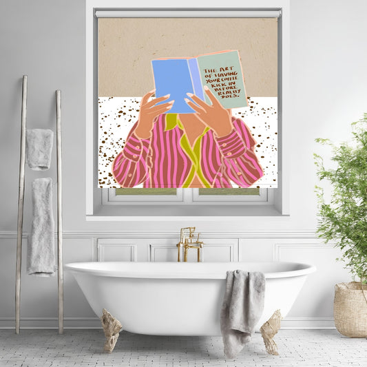 Printed roller blind featuring a graphic illustration of a person in a pink striped shirt holding a blue book with the quote The art of having your coffee kick in before reality does